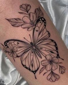 a black and white butterfly tattoo on the arm