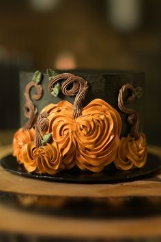 a black and orange cake with swirls on it's side sitting on a wooden table