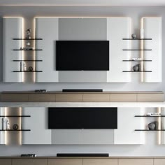 modern living room with white and black entertainment center, built - in shelving unit and floating shelves