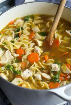 a pot filled with chicken noodle soup on top of a stove