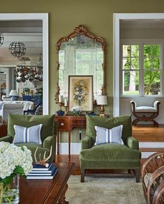 a living room filled with furniture and a mirror on top of a wall next to a doorway