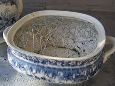 an old blue and white bowl sitting on top of a table next to other dishes