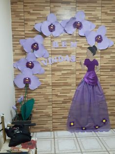 there is a dress made out of paper and flowers on display in front of a wall