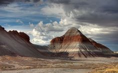 some very pretty mountains in the desert under a cloudy sky