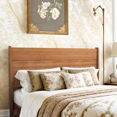 a bedroom with floral wallpaper and bedding in the corner, along with a painting on the wall