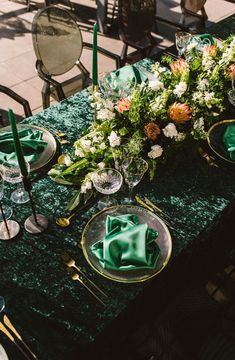 the table is set with green linens and place settings