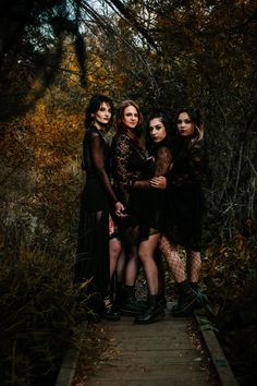 three women standing on a wooden walkway in the woods with their arms around each other