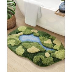 a bathroom rug with green and yellow flowers on it in front of a bathtub