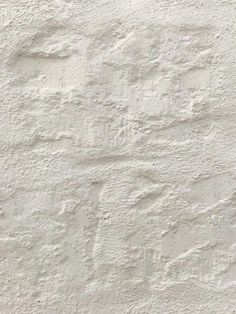 a white stucco wall with small cracks in it