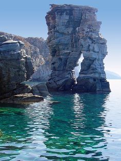 some rocks in the water and one is sticking out of it's rock face