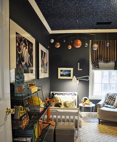 a room with black walls and pictures hanging on the wall, along with various toys