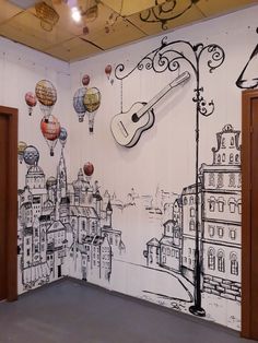 a room with a guitar and balloons painted on the wall