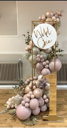 a table with balloons and decorations on it in front of a sign that says we are one