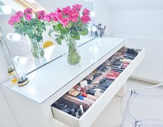 a vanity with flowers and makeup on it