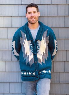 a man standing in front of a building wearing a sweater