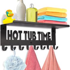 a towel rack with towels and soaps on it, next to a shelf that says hot tub time