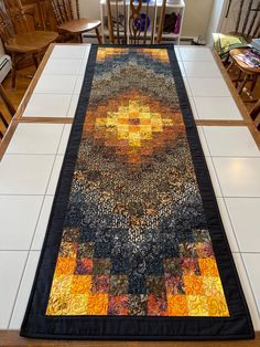 a table runner made out of old quilts on top of a tile floor in a dining room