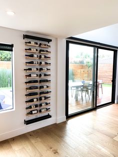 there is a wine rack in the corner of this room with sliding glass doors that lead to an outside patio