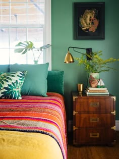 a bedroom with green walls and colorful bedding