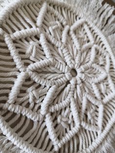 a white crochet doily on top of a wooden table