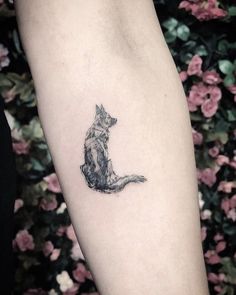 a small cat tattoo on the arm