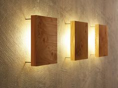 three wooden lights are mounted on the wall