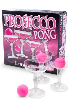 three wine glasses with pink balls in front of a boxed box for the game prosteco pong