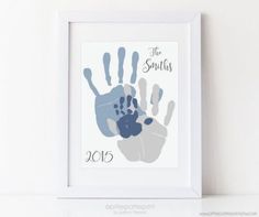 a white frame holding a blue and gray hand print