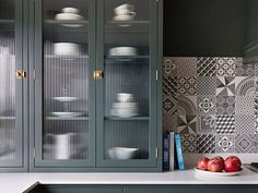 a kitchen with green cabinets and white plates