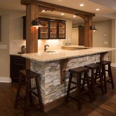 a kitchen with two stools and an island in the middle of the room is lit by recessed lights