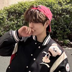 a young man wearing a black and white jacket with a red bandanna on his head