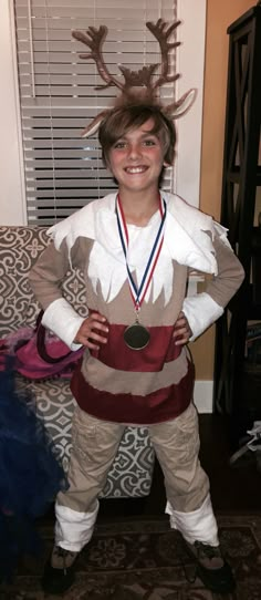 a young boy dressed up as a reindeer with a medal around his neck and chest