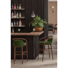 two green chairs sitting in front of a bar