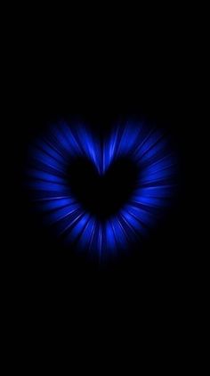 a heart shaped object in the dark with blue light coming from it's center