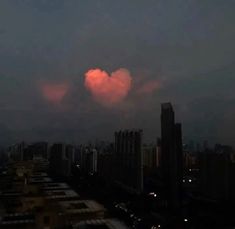 pink cloud in the sky over city skyline at night with buildings and skyscrapers lit up