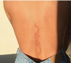 the back of a woman's stomach with a small tattoo on her left side