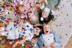 group of children lying on floor surrounded by confetti