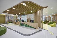 the interior of a modern office building with wood slats and green seating areas on both sides