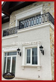 an image of a house that is white and has black balconies on the balcony