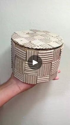 someone is holding an origami box that looks like it's made out of cardboard