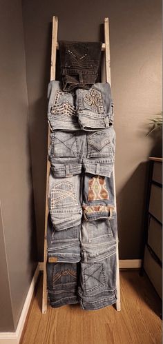 a ladder that is holding several pairs of jeans