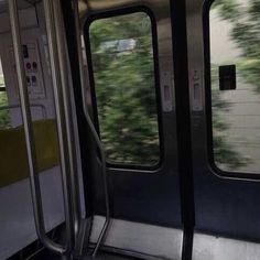 the inside of a subway car with trees in the background and open doors on both sides