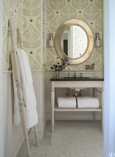 a bathroom with a sink, mirror and towel rack on the wall in front of it