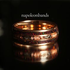 a close up of a ring on a black surface with the words mapleton bands written above it