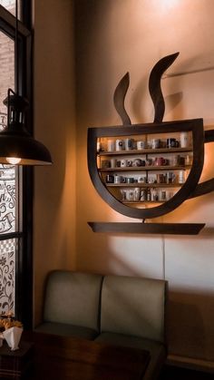 a coffee shop is decorated with an artistic design and unique lighting fixture, along with a bench in front of the window