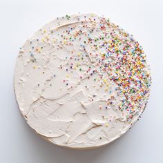 a white frosted cake with sprinkles on it