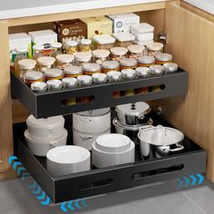 an open drawer with dishes and cups on it in a kitchen under the countertop