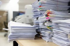 a stack of papers sitting on top of a desk