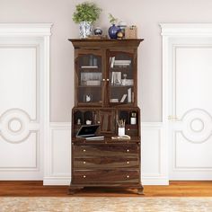 an old wooden cabinet with glass doors and drawers in the middle of a living room