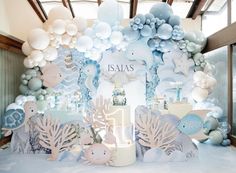 a room with balloons and decorations on the wall for a baby's first birthday